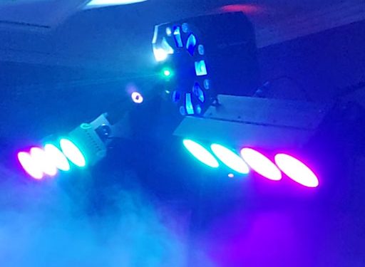 2 LED Bars und ein Center-Lichteffekt auf Stativ beleuchten den Raum zur Musik in blau, lila und grünem Laserlicht